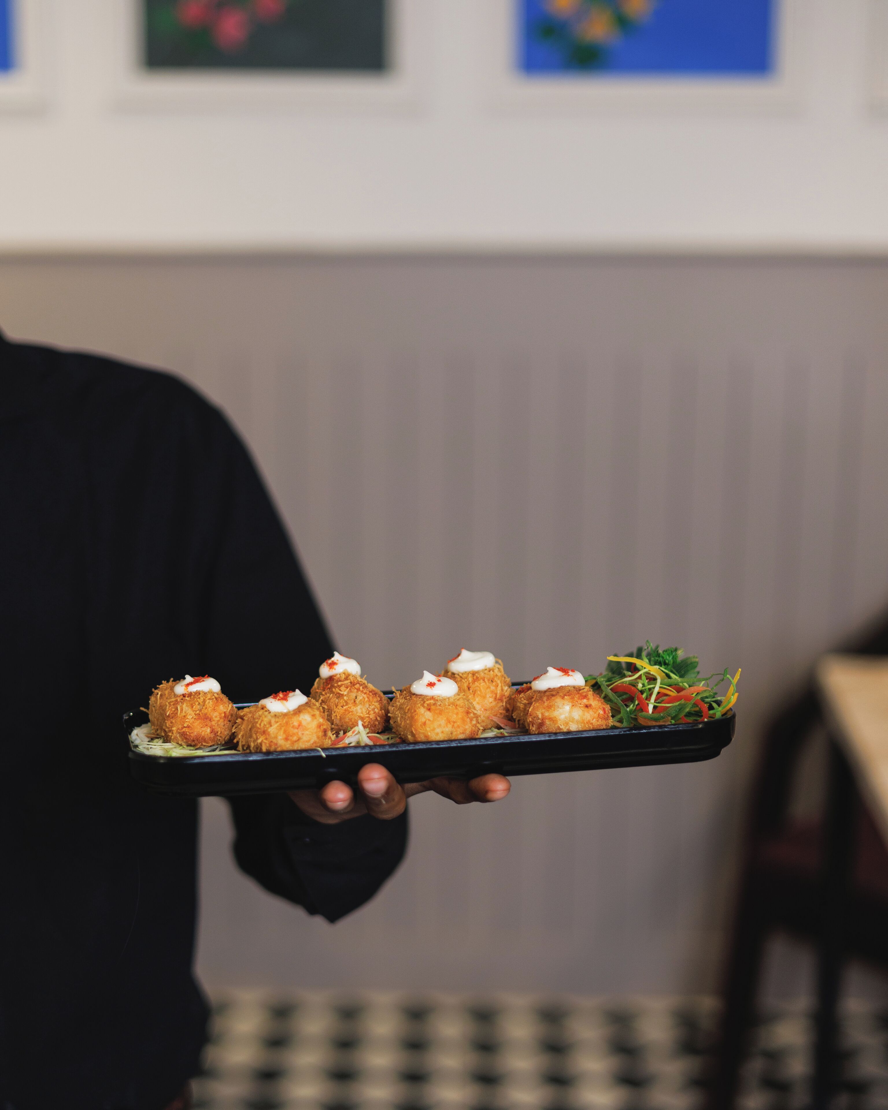 A person holding a tray with food items.