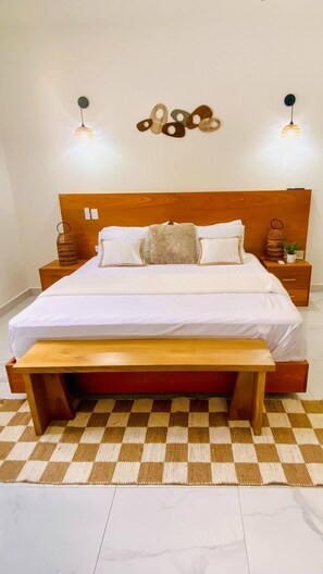 Restful retreat with a large bed, bedside tables, and a wall-mounted light fixture.