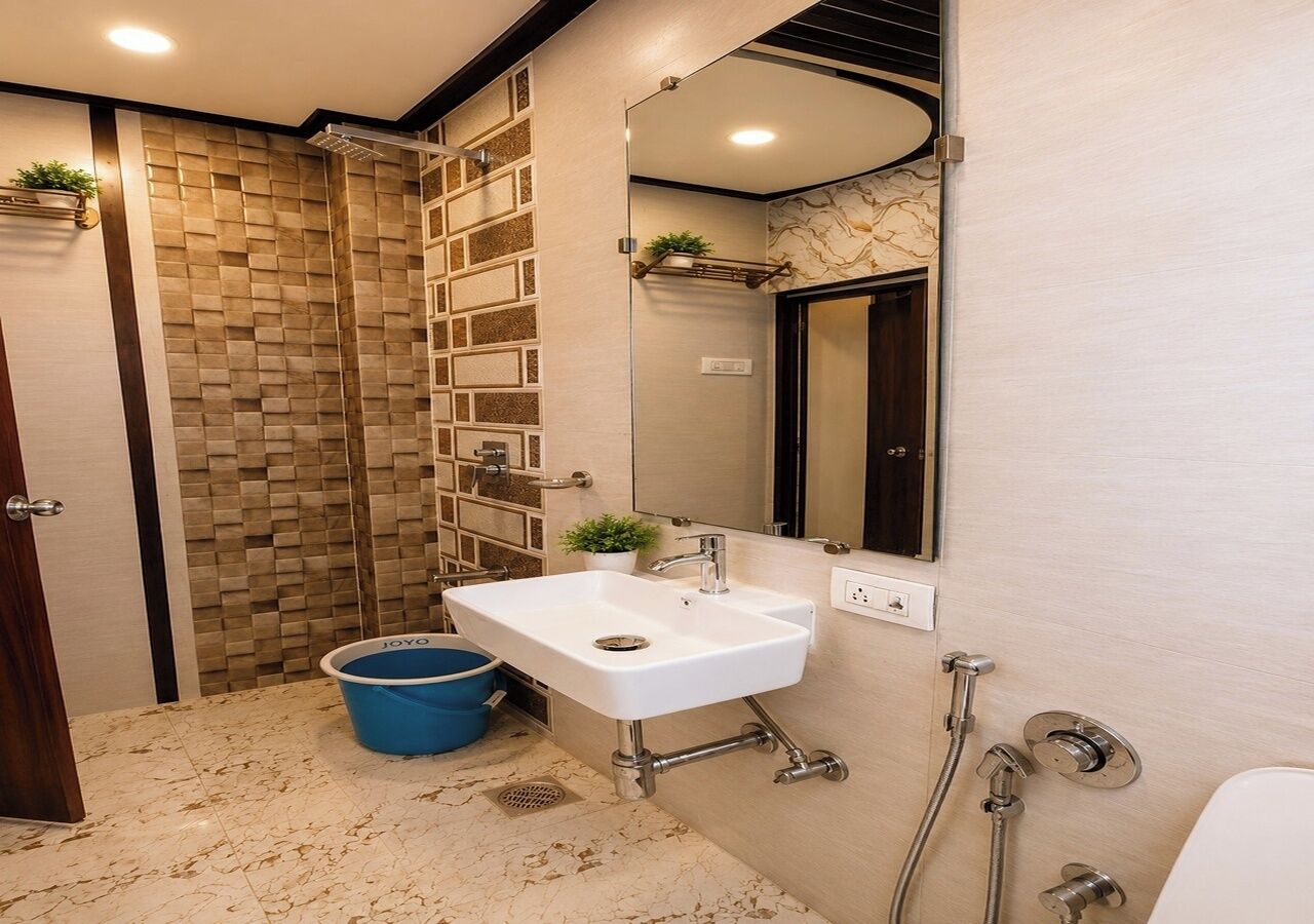 A bathroom with a white sink, a shower, and a mirror.