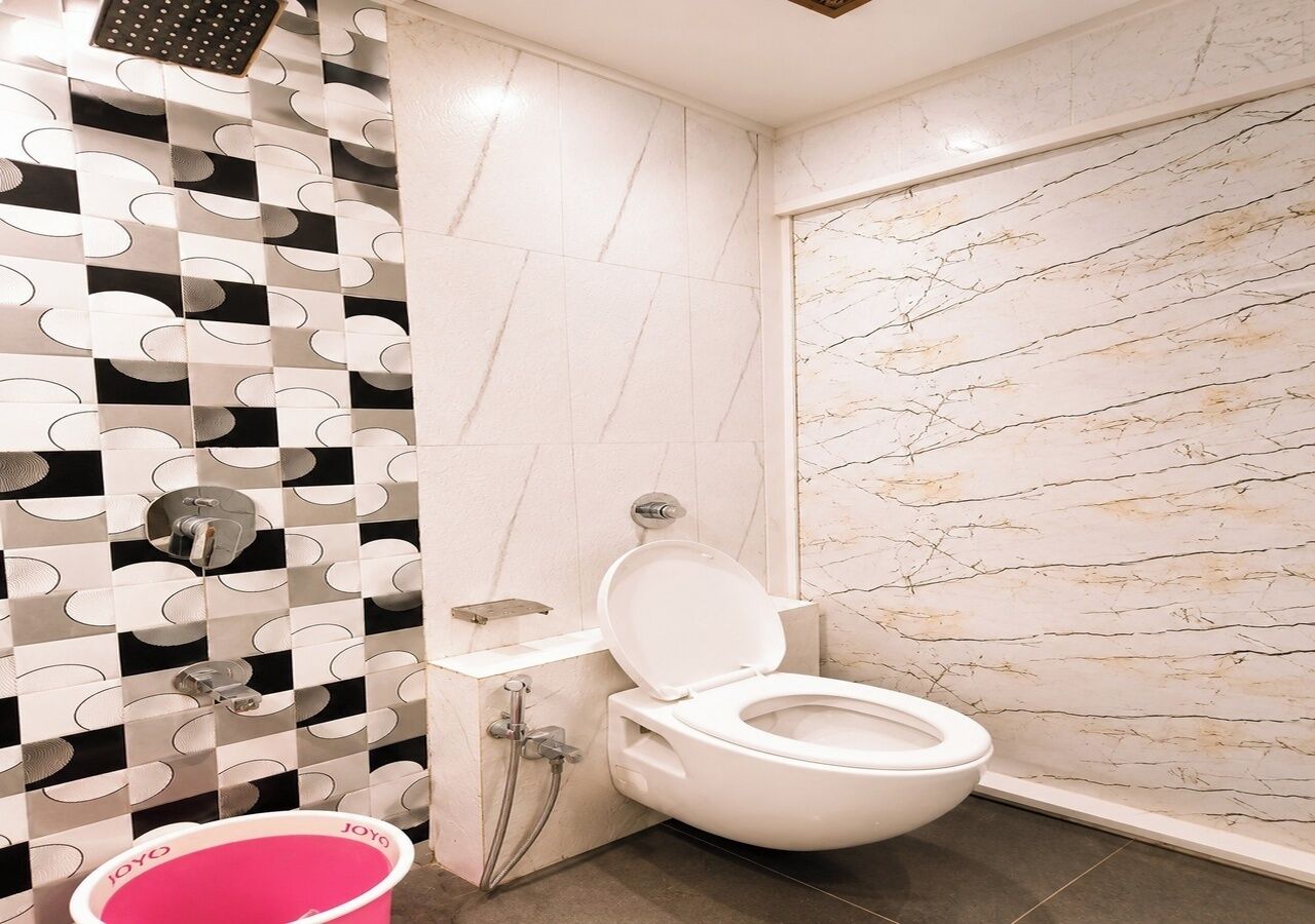 Et badeværelse med toilet, brusebad og håndvask.