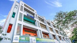 A multi-story building with commercial spaces on the ground floor, featuring signage for services like an e-lobby and a restaurant. - New Seven Hills By Glitz Hotels (Mumbai)