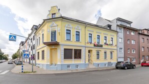 Un edificio amarillo con un letrero que dice "HOTEL" y una señal de paso para peatones cerca.