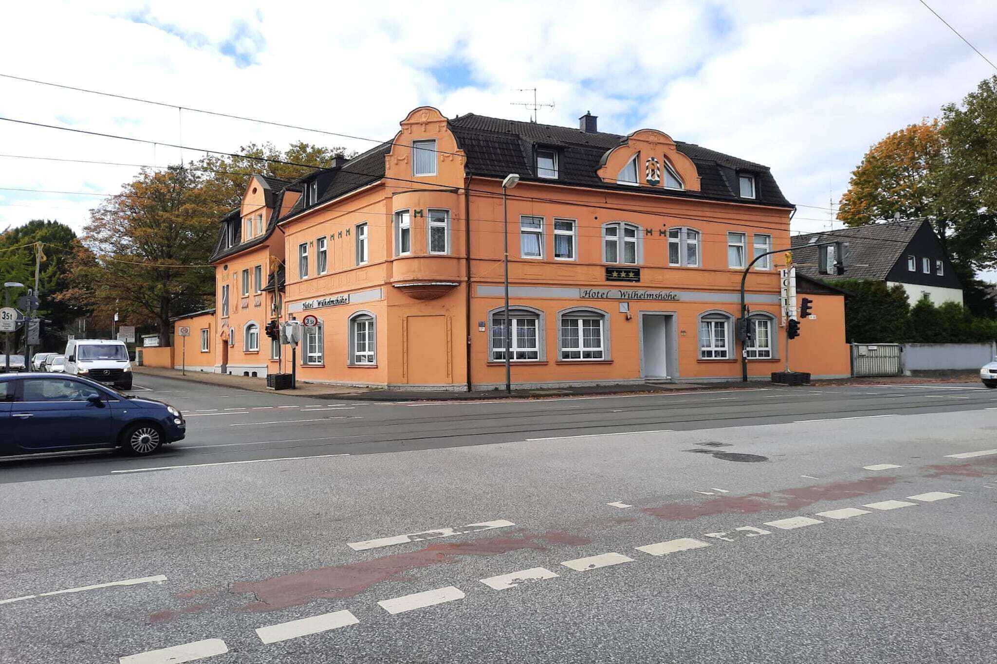 Un edificio anaranjado grande con un cartel que dice 'Hotel Wilhelmshöhe' y una clasificación de '4 estrellas'.