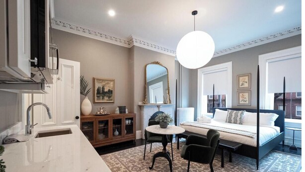 Une chambre à coucher moderne avec un lit, une table de chevet et un grand miroir.