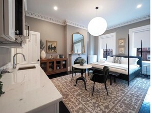 Une chambre à coucher moderne avec un lit, une table de chevet et un grand miroir.