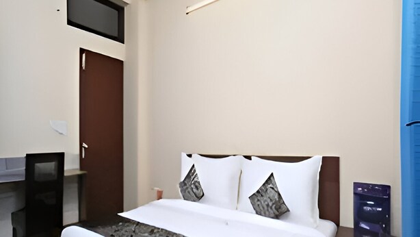 Hotellihuone, jossa on sänky, työpöytä ja tuoli.