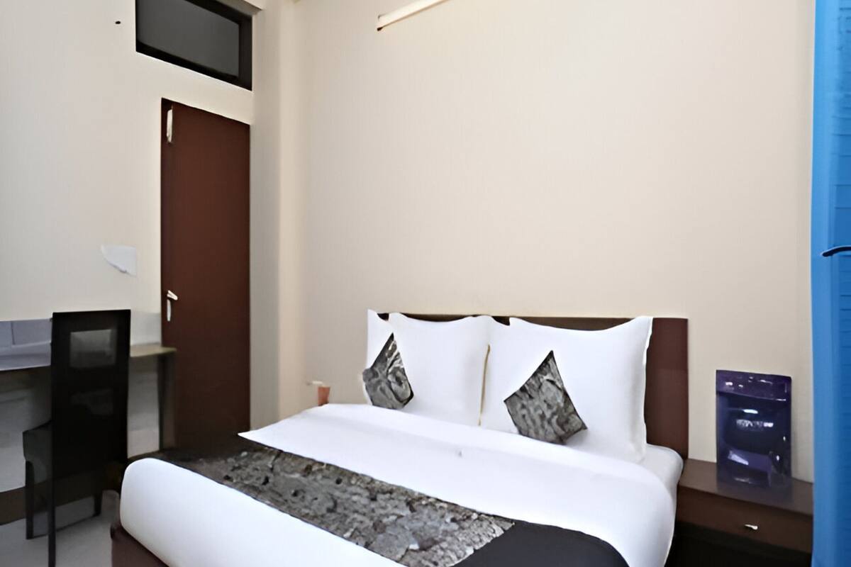 A hotel room with a bed, a desk, and a chair.