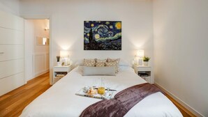 A hotel room with a bed, bedside tables, a painting, and a breakfast tray. - Civico36 Feels Like Home (Cagliari)