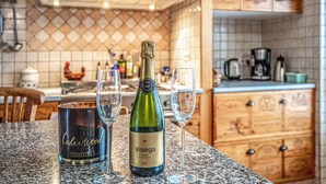 Una cocina con una botella de vino cava Visiege, dos copas y una vela etiquetada como Cedro.