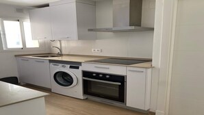 Una cocina compacta equipada con lavadora, horno y cocina integrada.
