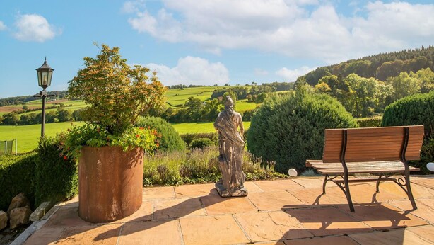 A patio with a statue, a bench, and a lamppost. - Stunning holiday home in Theux (Theux)