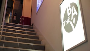 Una scala con un display digitale dell'ascensore e un poster appeso al muro.