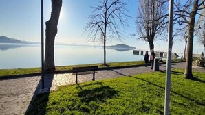 A park with a bench, trees, and a view of a calm lake. - Charming Family Retreat in Umbria (Mantignana)