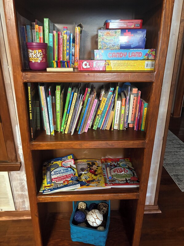 A bookshelf with various books, including children's books and board games.