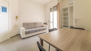 Un salon moderne comprenant un canapé, une table à manger et une armoire intégrée.