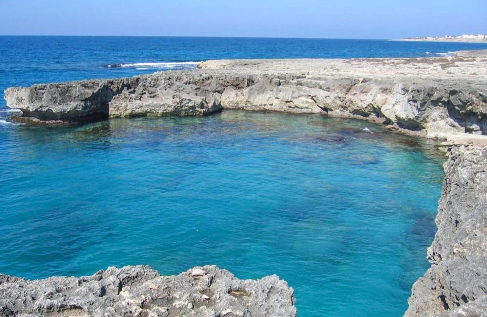 A rocky coastline with clear blue waters.