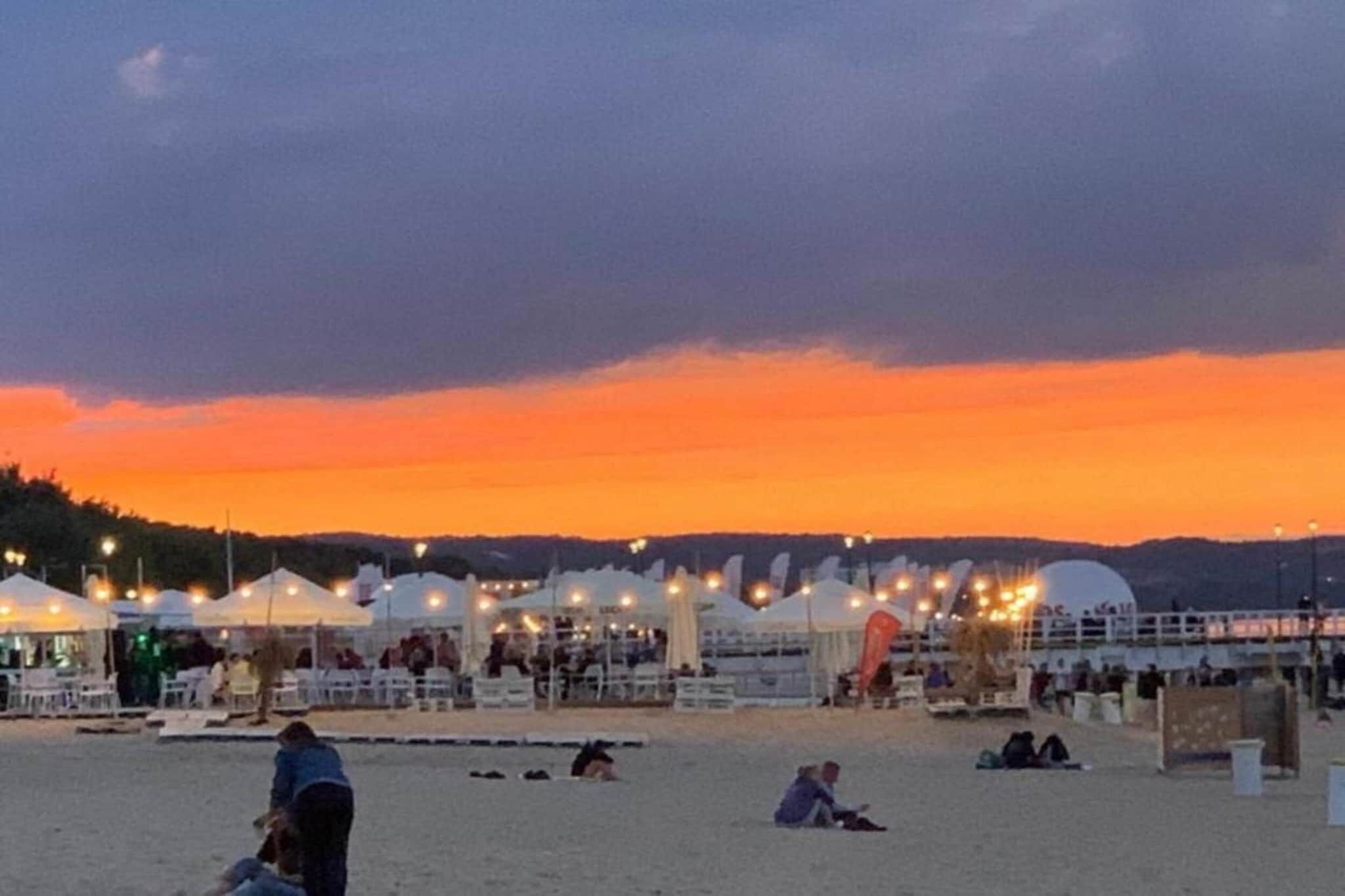 Una playa con tiendas de campaña y gente.