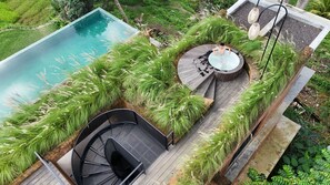 A rooftop pool with a hot tub and a seating area surrounded by lush greenery. - Rumah Subak  (Tampaksiring)