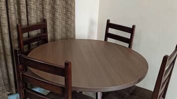 A round wooden dining table with four matching chairs.