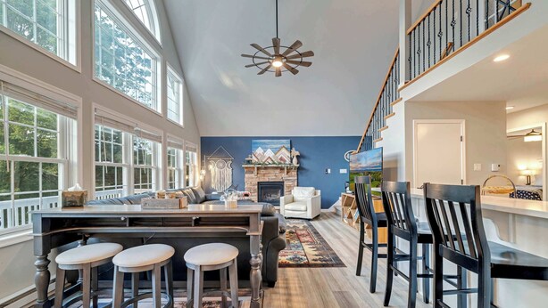 A spacious kitchen with a large island, bar stools, and a fireplace. - Hot Tub, Game Room, Dog Friendly, Sports Bar, A/C (Albrightsville)