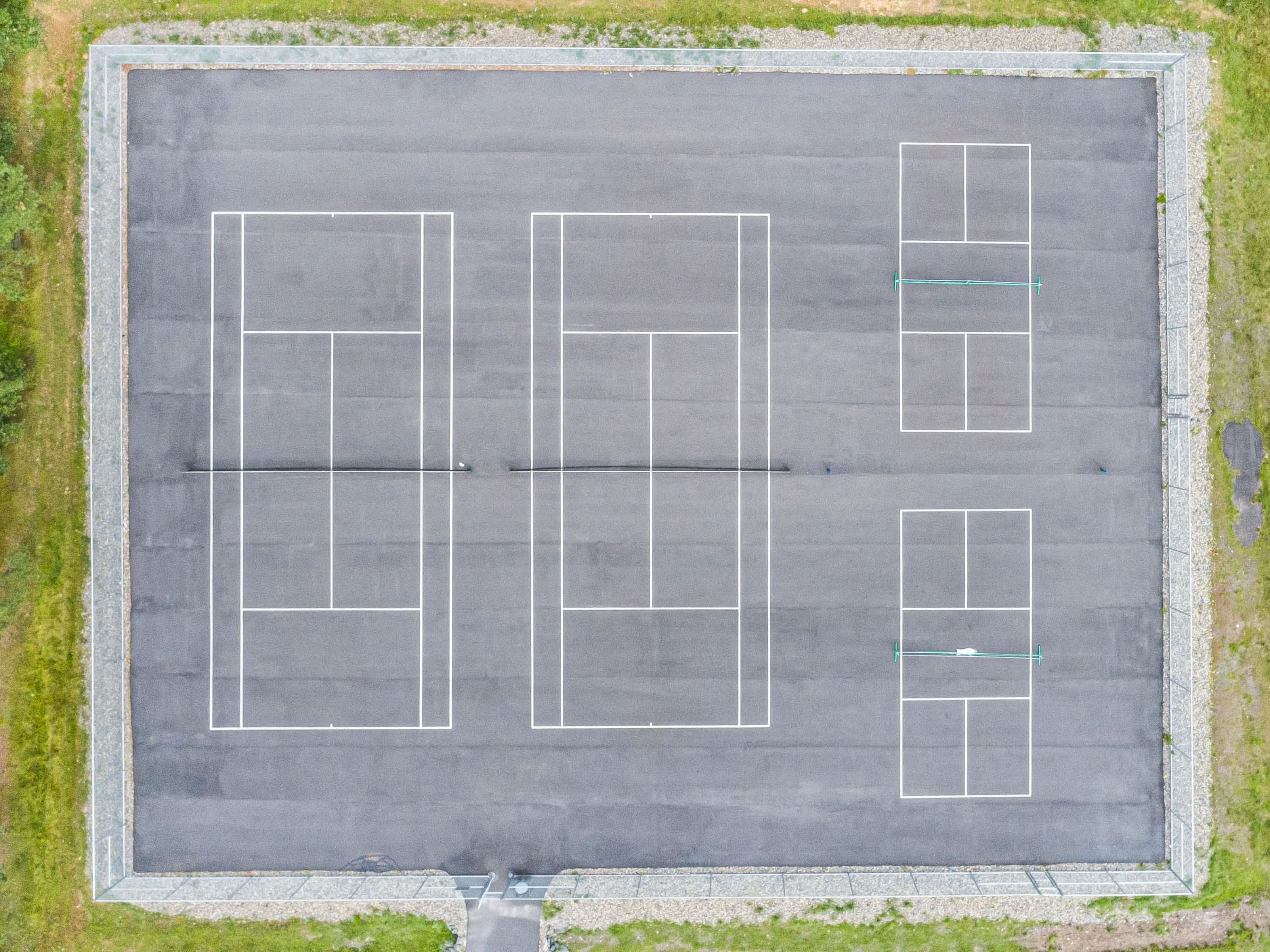 Vue aérienne d’un parking comportant de nombreuses places de stationnement délimitées et un chemin piétonnier central.