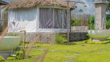 Guest rooms offer a serene escape adjacent to a beautifully maintained garden with a variety of plants.