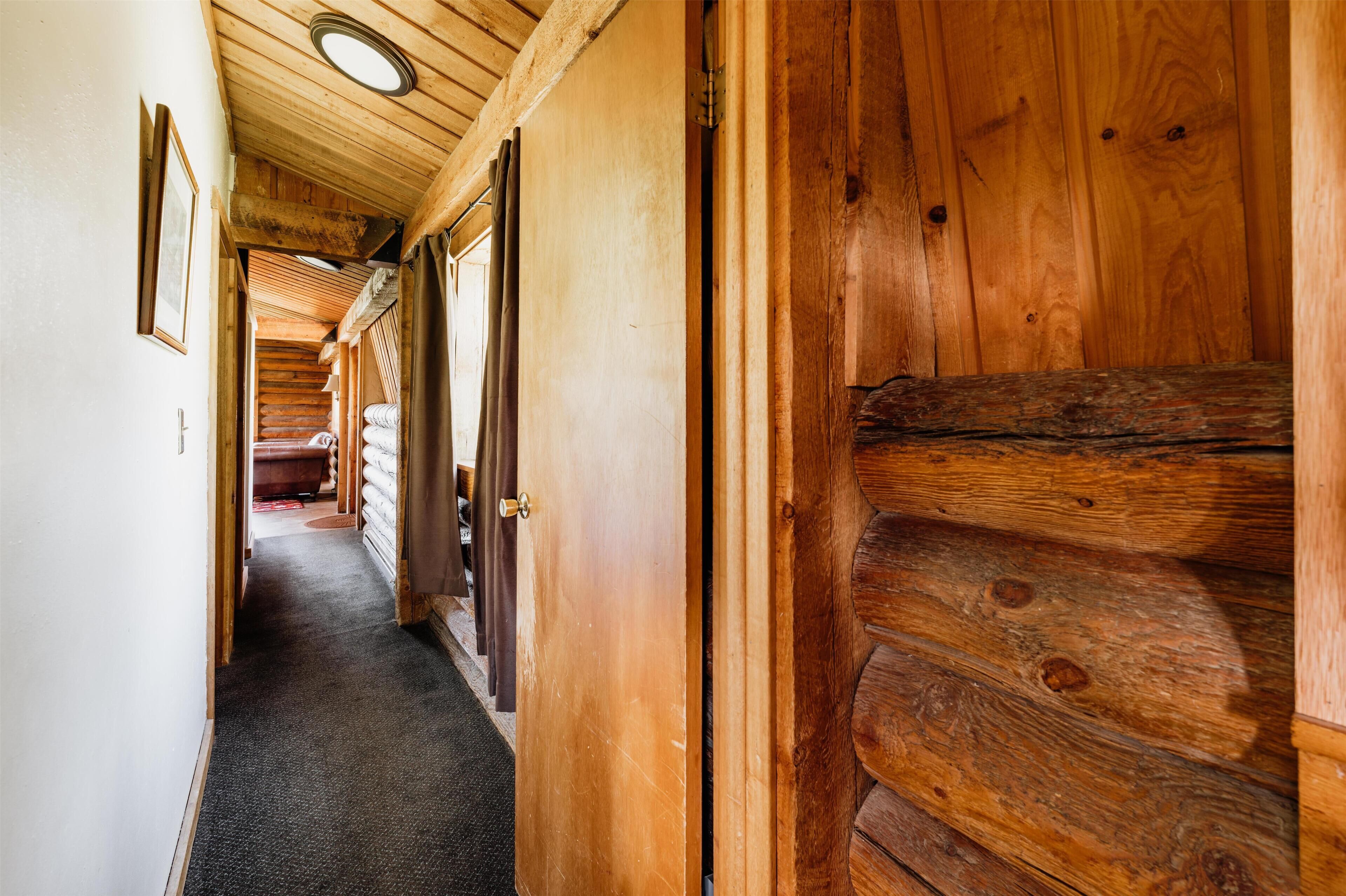 Ein Holzboden-Flur mit einer Tür zu einem Zimmer.