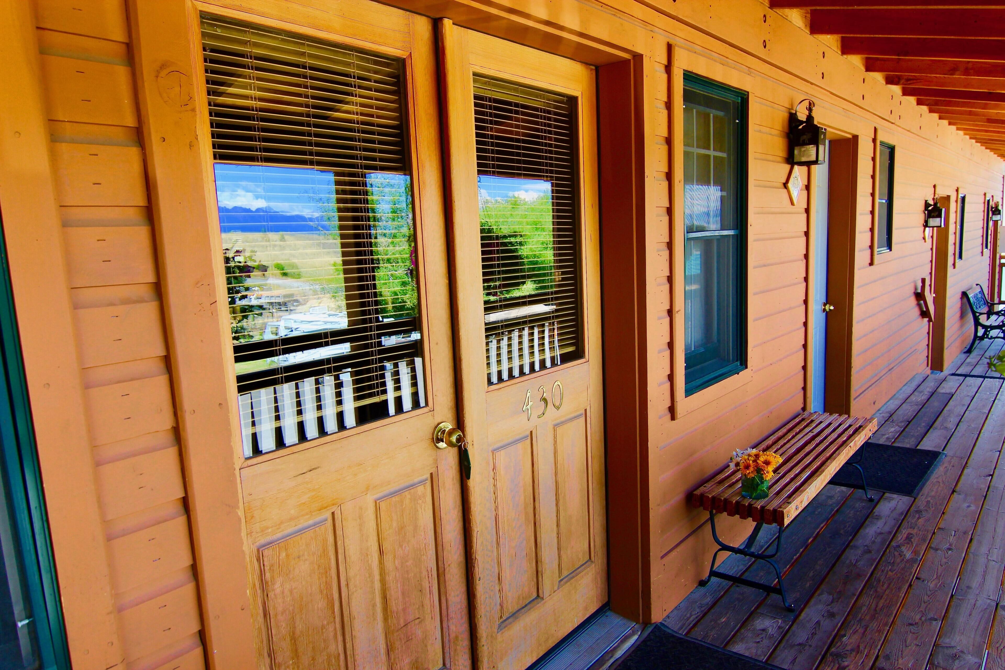 A wooden house with a porch, a bench, and a door with the number 430.