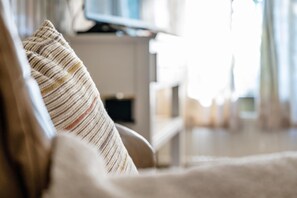 A close-up of a striped pillow on a couch with a blurred background of a room. - "Fewo Ebbe, Hof Harrsen, where tranquillity has its home" (Pellworm)