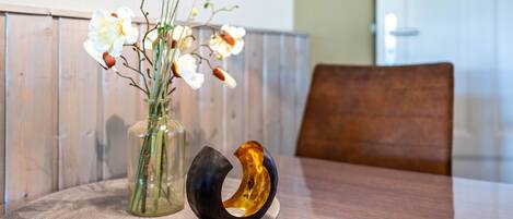 Una mesa redonda con un florero y un cuenco decorativo.