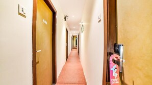 A hotel hallway with doors numbered 606 and 607, a 'DON'T DISTURB' sign, and a security camera. - Ascot By Glitz Hotels (Mumbai)