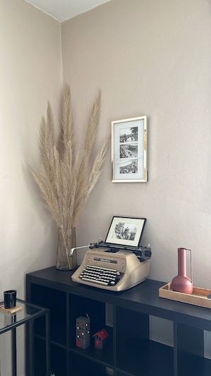 Un escritorio con una máquina de escribir Remington, una fotografía enmarco y pastos de pampa.
