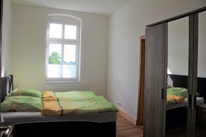 Une chambre à coucher avec un lit, une fenêtre et une porte.