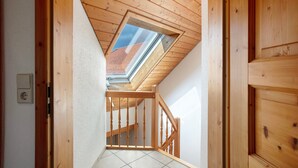 A wooden staircase with a skylight leading to an upper floor.
