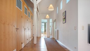 A hallway with wooden lockers, a brown rug, pendant lights, and a framed picture on the wall. - Holiday Apartment 'Alte Seifensiederei - Ferienloft' with Wi-Fi (Stralsund)