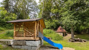 A rustic wooden cabin with a large blue slide in front. - Apartment 'Donnerberg' with Shared Terrace, Shared Garden and Wi-Fi (Ühlingen-Birkendorf)
