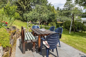 A wooden outdoor table with chairs, a checkered tablecloth, and a glass of water. - Apartment 'Donnerberg' with Shared Terrace, Shared Garden and Wi-Fi (Ühlingen-Birkendorf)