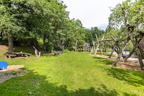Un parc doté d’une pelouse, de structures en bois et d’arbres.