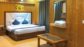 Een kamer met houten lambrisering, een bed, een tafeltje en een spiegel.