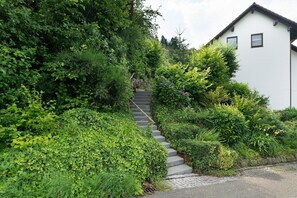 A residential area with a staircase leading to a white house, surrounded by lush greenery. - Apartment 'Ferienwohnung Wintereck' with Mountain View (Bühlertal)