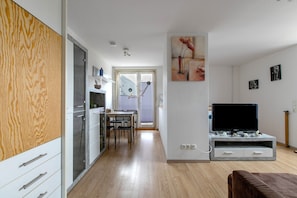 Eine moderne Küche mit Essbereich, einem Fernseher und einem Holzkabinett.