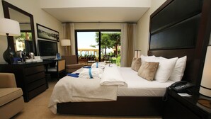 A hotel room with a bed, a desk, a TV, and a view of the outdoors.
