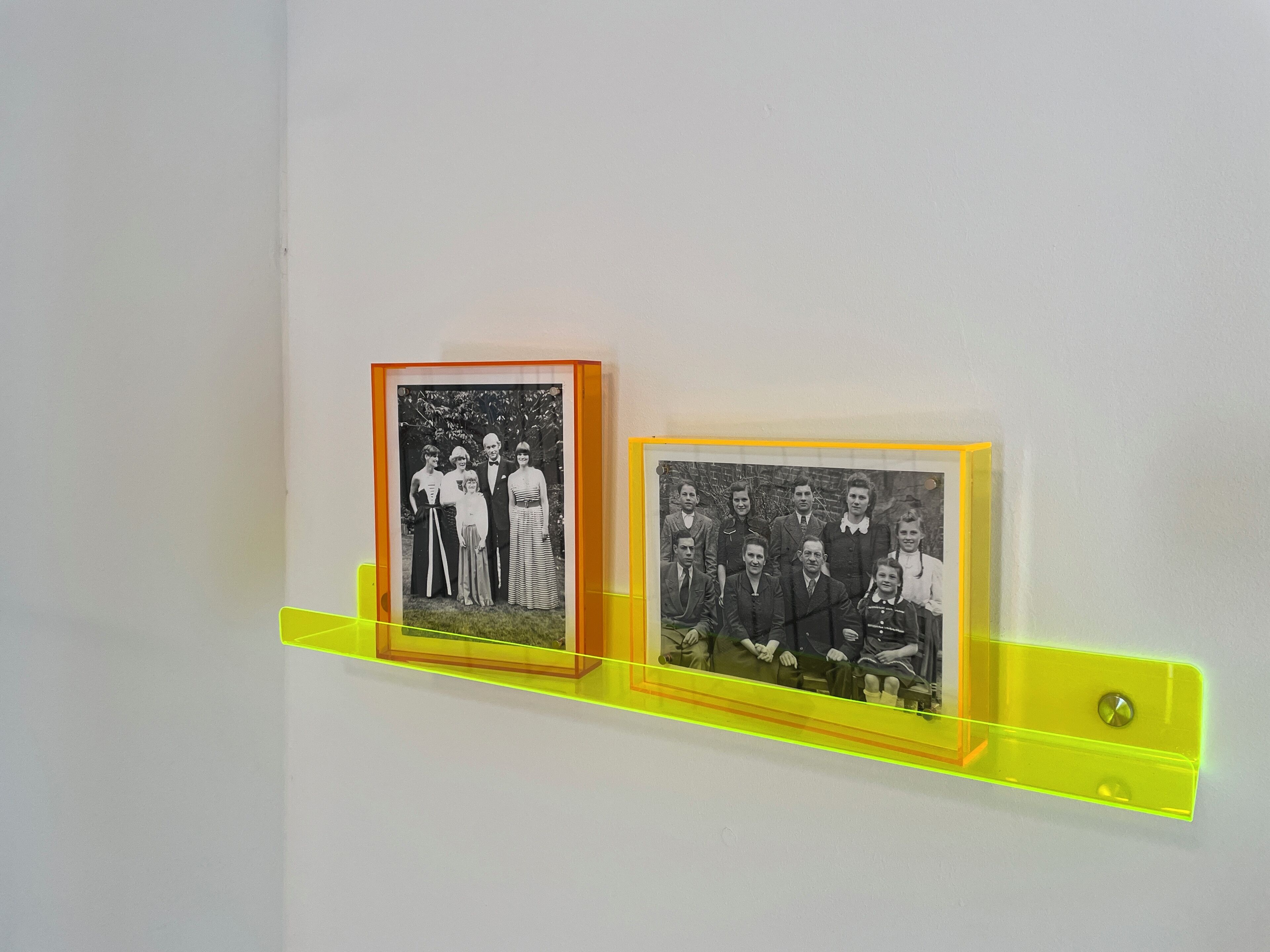 Zwei gerahmte Schwarz-Weiß-Fotos an einer Wandhalterung.