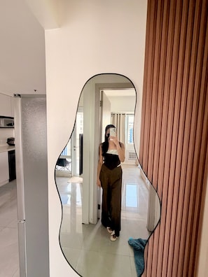En person tar en selfie i en hall, och en stor spegel reflekterar rummet.