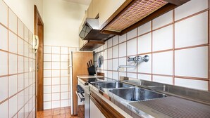 A kitchen with a built-in stove, a sink, and a ventilation hood.
