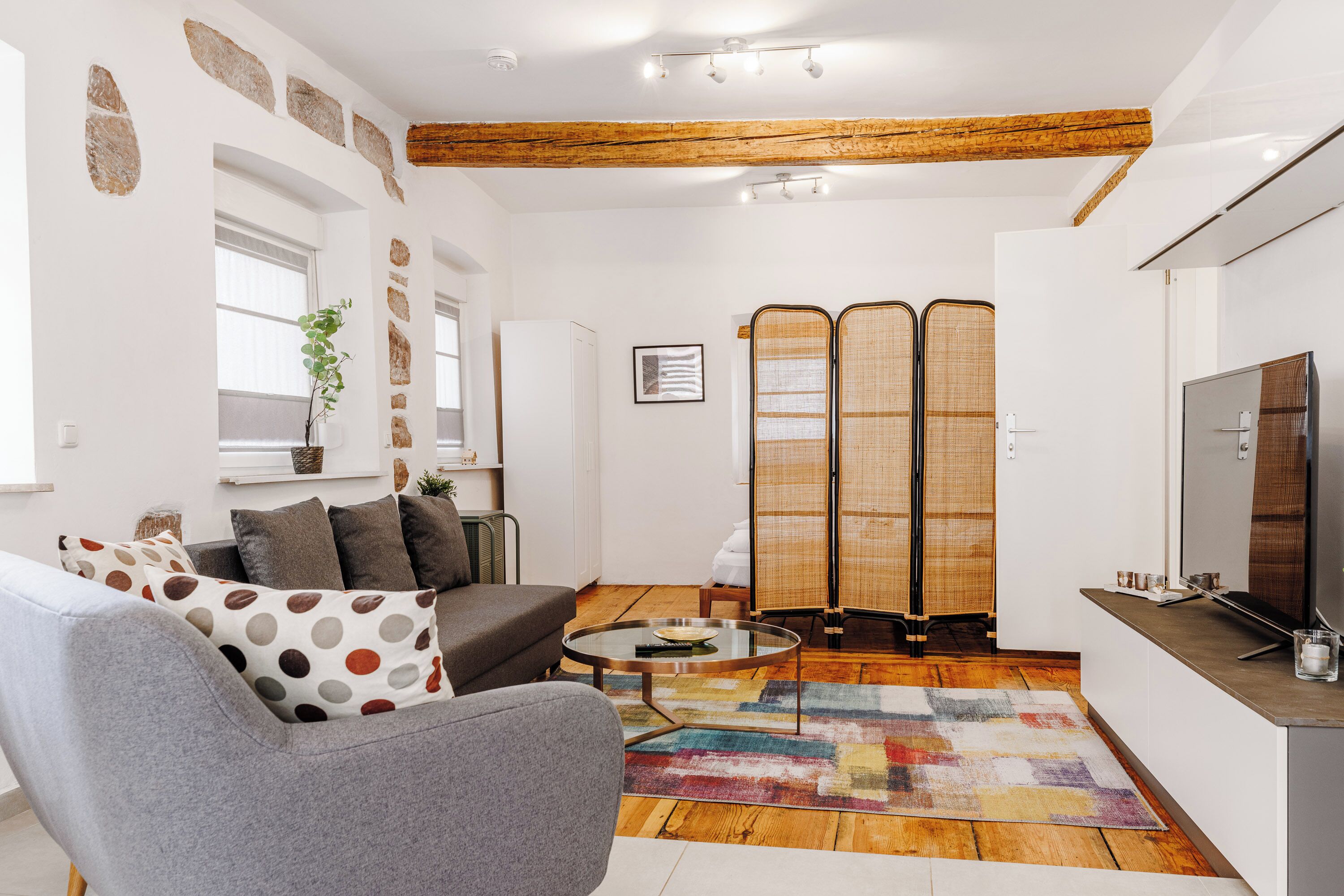A modern living room with a sofa, coffee table, and a TV.