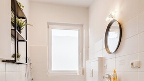 Un baño pequeño con inodoro, lavabo y lavadora.