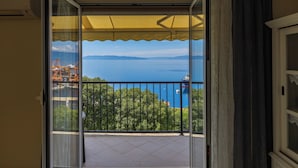 Un balcón con vista al mar y a las montañas.