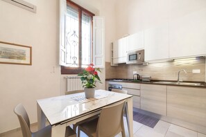 Une cuisine moderne avec des meubles blancs, un four à micro-ondes et une fenêtre donnant sur un beau paysage.