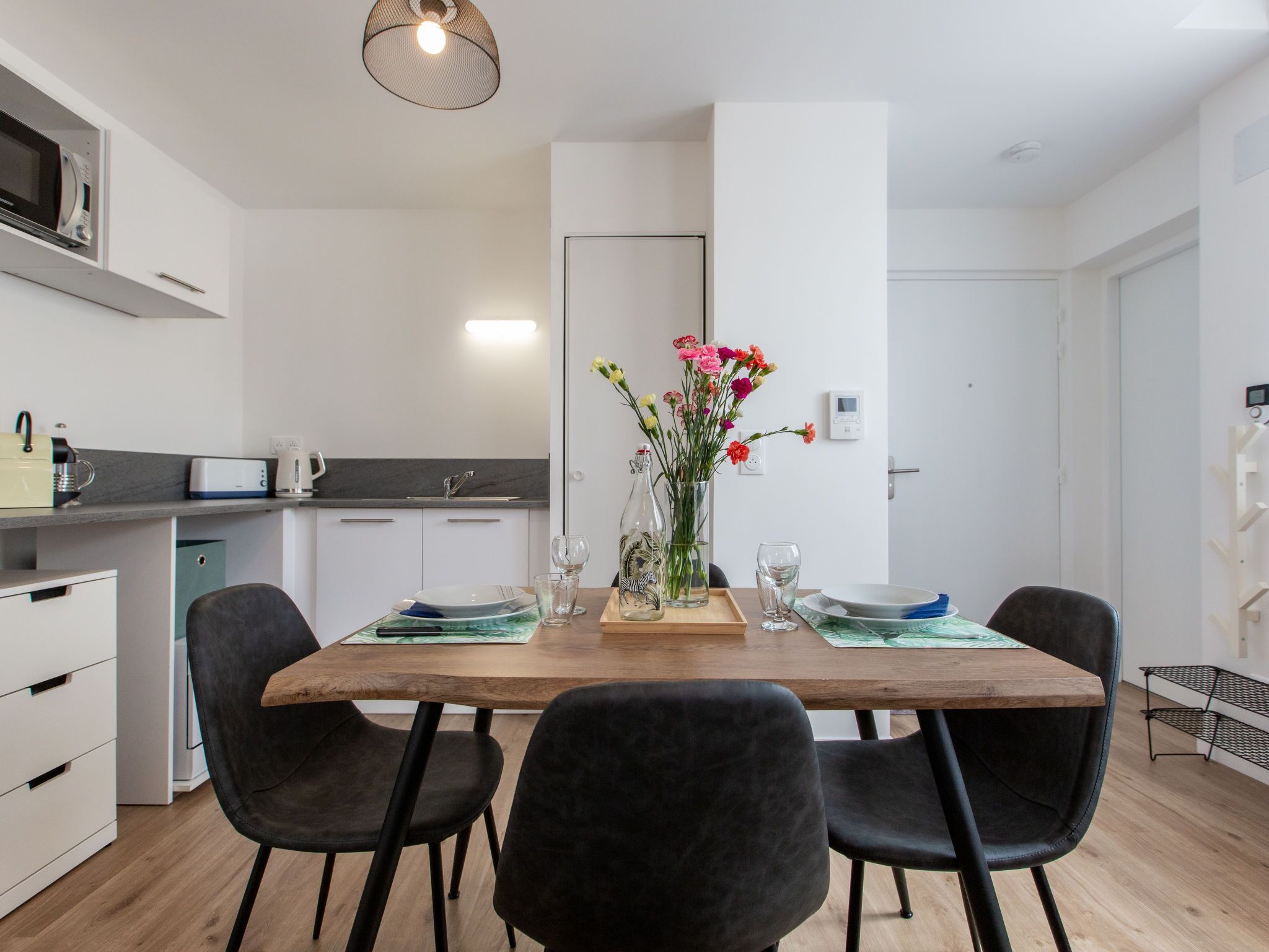 A modern kitchen with white cabinets, a built-in microwave, and a grey countertop.